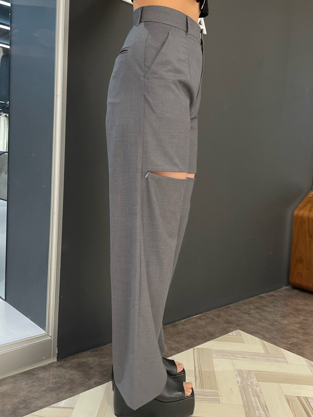 ブラック系のTシャツ/カットソー、グレー系のその他パンツ、ブラック系のサンダルを着用したレディースの春コーディネートの7枚目の写真