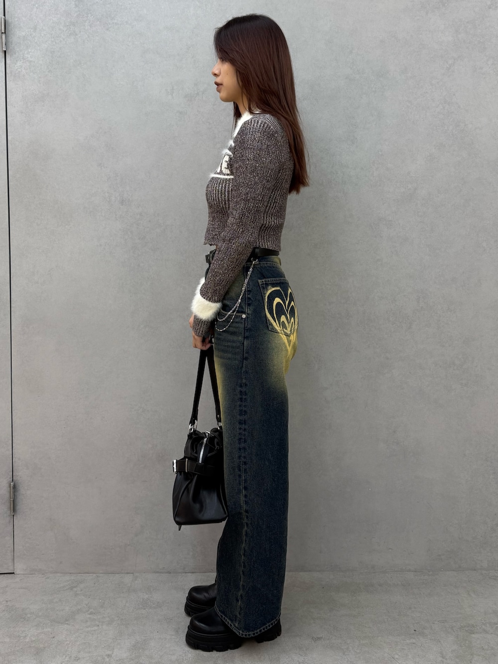 ブラウン系のニット/セーター、ブルー系のデニムパンツ、ブラック系のトートバッグを着用したレディースの冬コーディネートの2枚目の写真