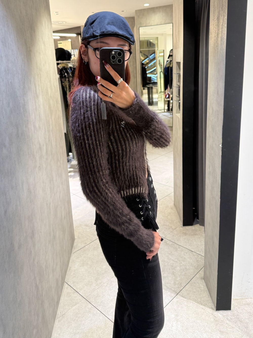 ブラウン系のニット/セーター、ブラック系のデニムパンツ、ブラック系のブーツを着用したレディースの秋コーディネートの5枚目の写真