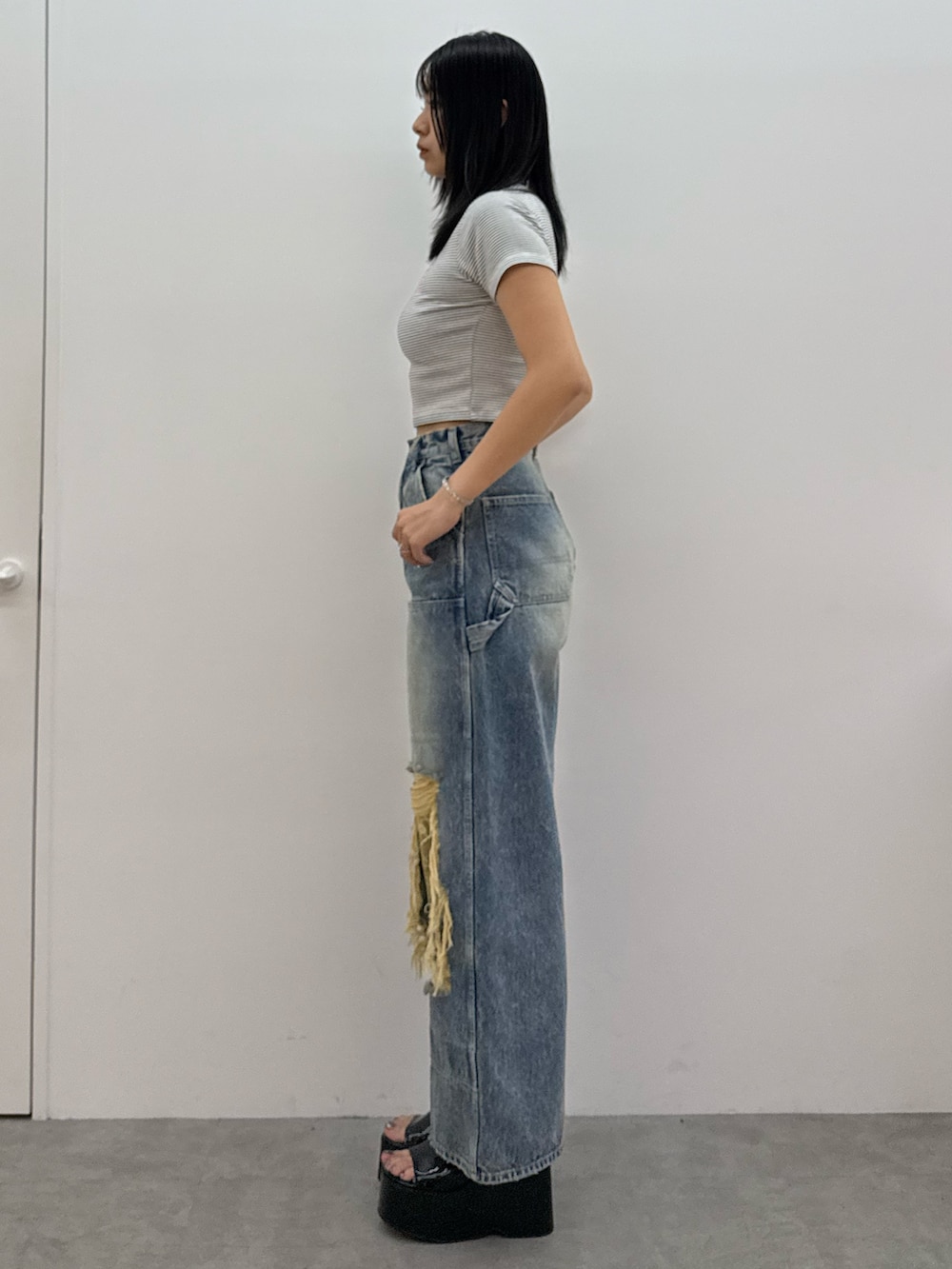 ブラック系のサンダル、ブルー系のデニムパンツ、ホワイト系のTシャツ/カットソーを着用したレディースの春コーディネートの2枚目の写真