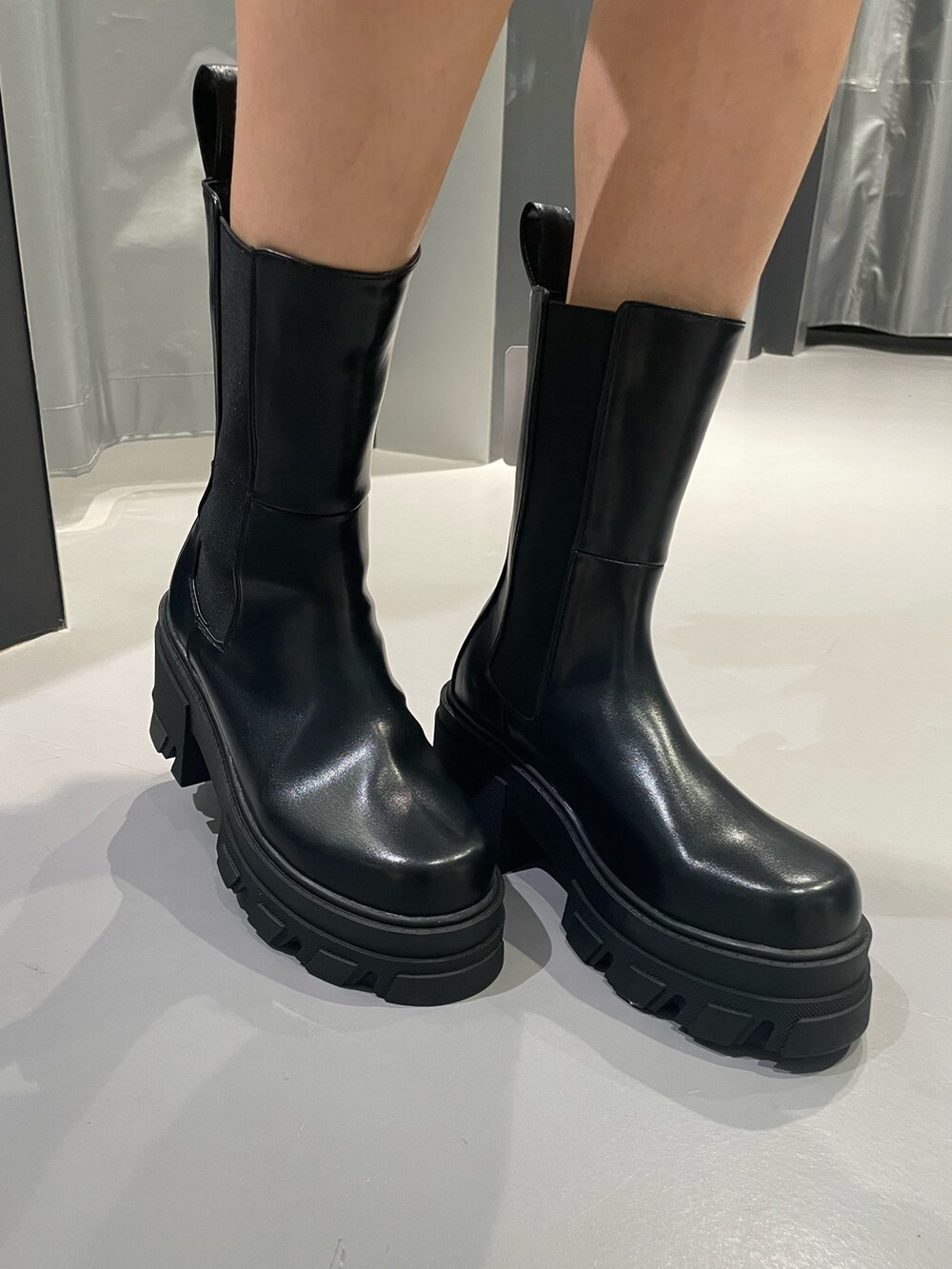 ピンク系のニット/セーター、グレー系のスカート、ブラック系のハンドバッグを着用したレディースの夏コーディネートの9枚目の写真