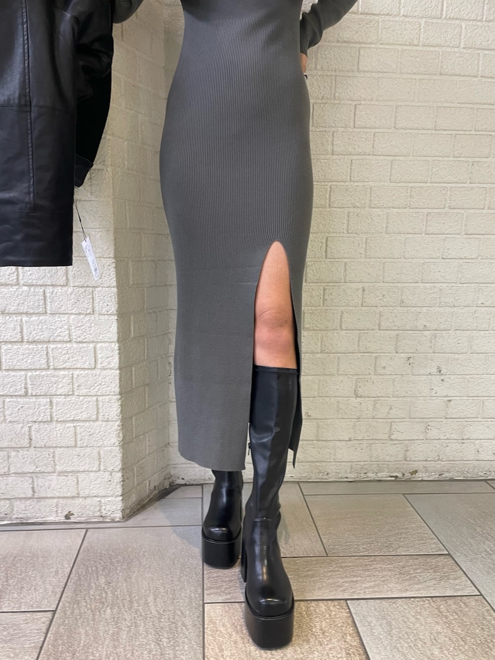 ブラック系のブルゾン、グレー系のワンピース、ブラック系のブーツを着用したレディースの秋コーディネートの9枚目の写真