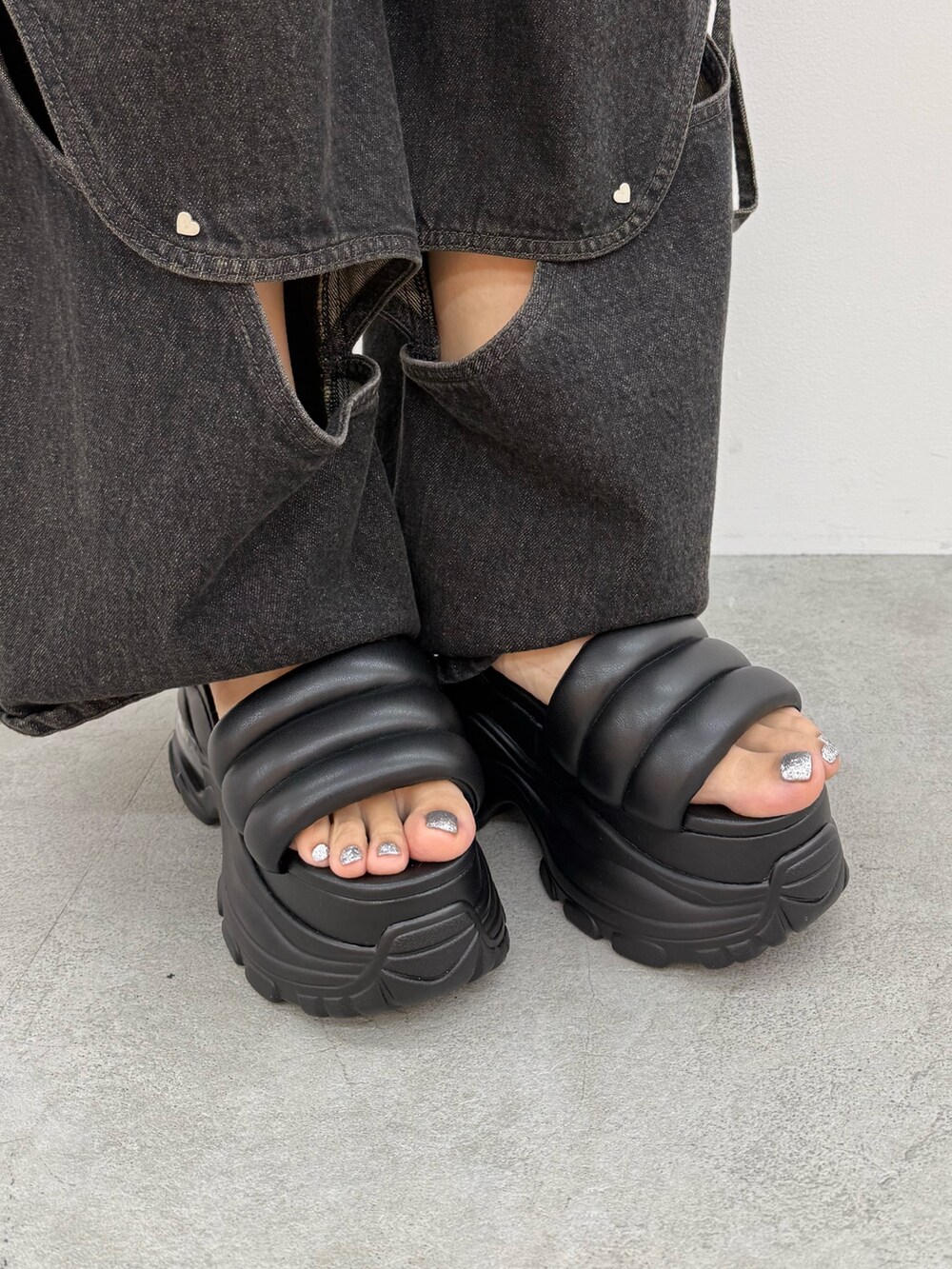 ブラック系のニット/セーター、ブラック系のデニムパンツ、ブラック系のハンドバッグを着用したレディースの夏コーディネートの10枚目の写真