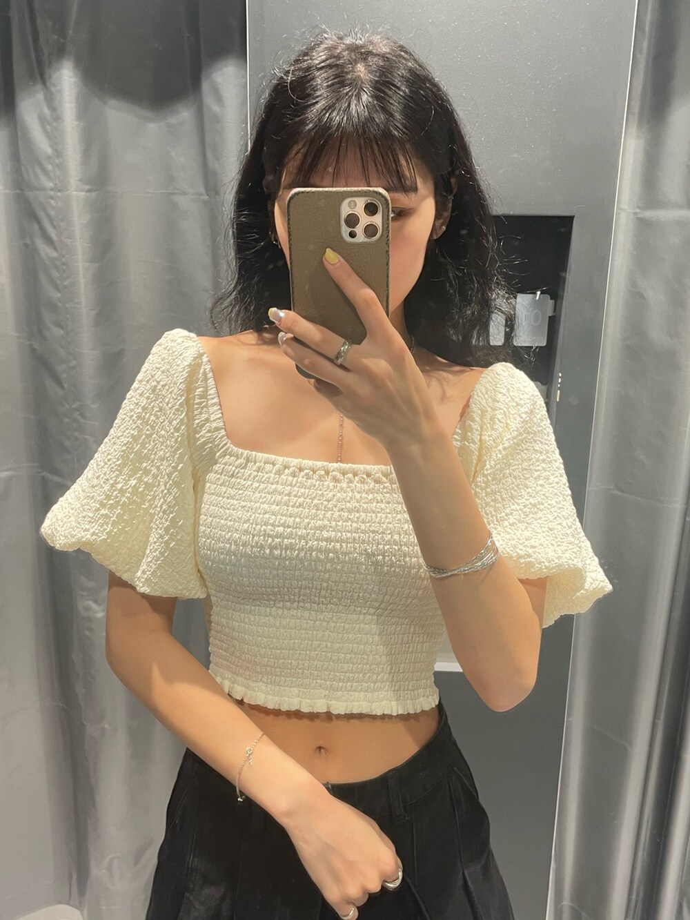 ホワイト系のTシャツ/カットソー、ブラック系のデニムスカート、ブラック系のショルダーバッグを着用したレディースの春コーディネートの4枚目の写真