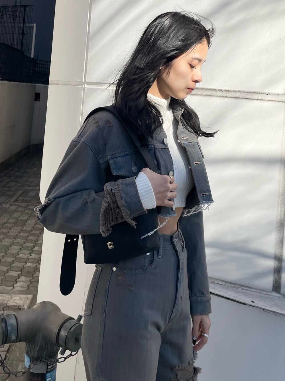 ホワイト系のニット/セーター、グレー系のデニムジャケット、グレー系のデニムパンツを着用したレディースの冬コーディネートの5枚目の写真
