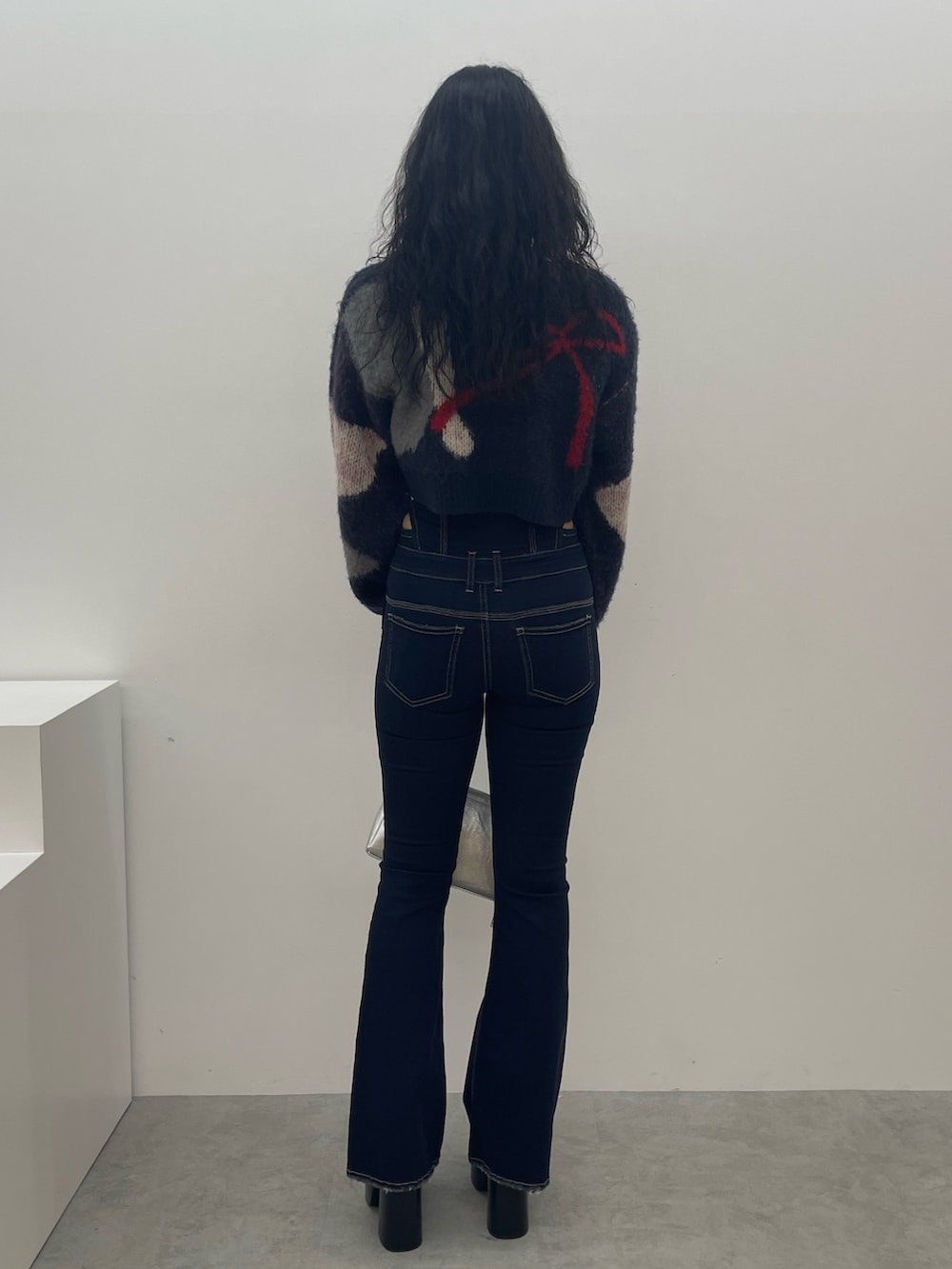 ブルー系のニット/セーター、ブルー系のデニムパンツ、ブラック系のブーツを着用したレディースの夏コーディネートの3枚目の写真