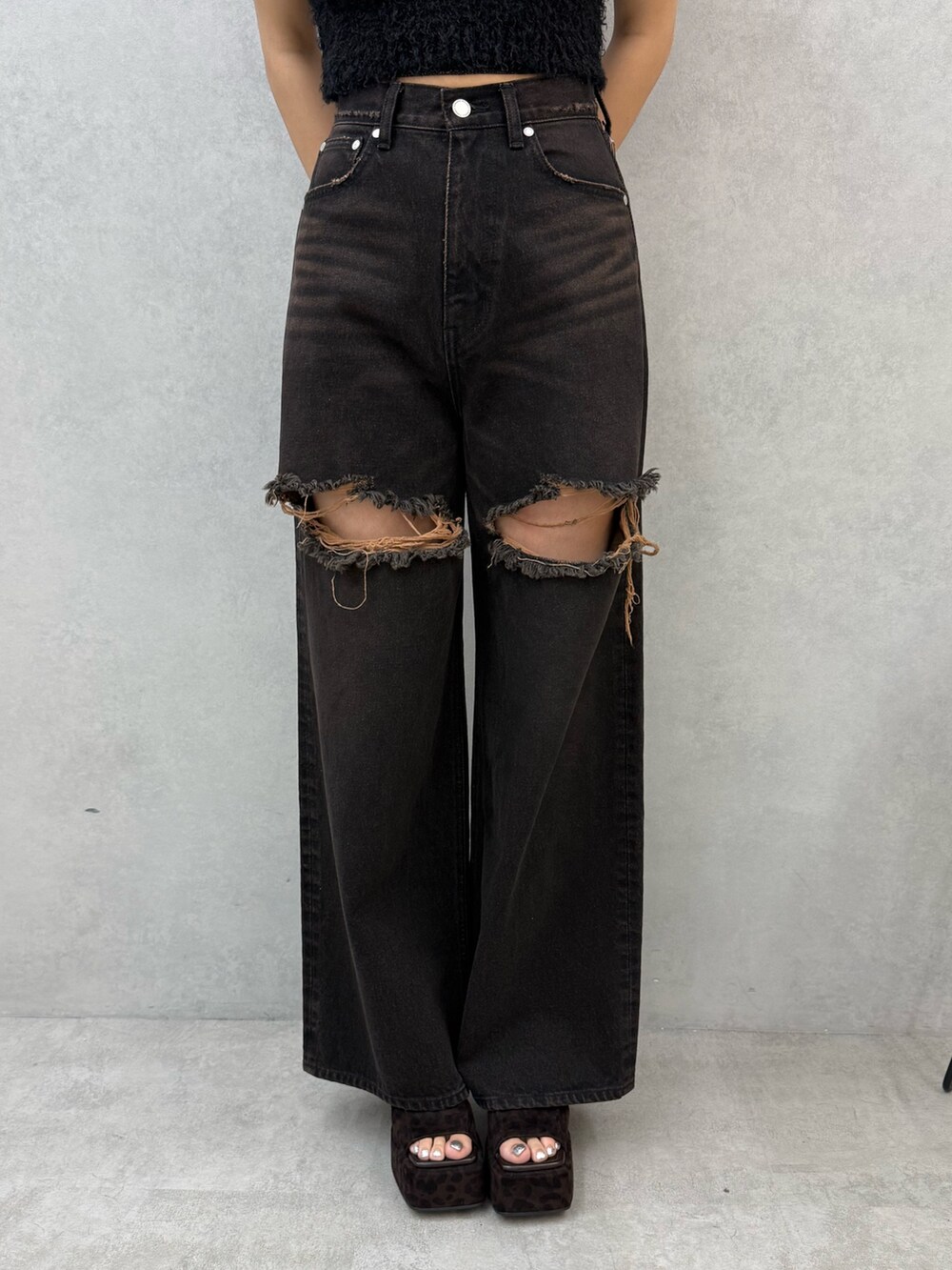 ブラック系のニット/セーター、ブラック系のデニムパンツ、ブラウン系のサンダルを着用したレディースの夏コーディネートの7枚目の写真