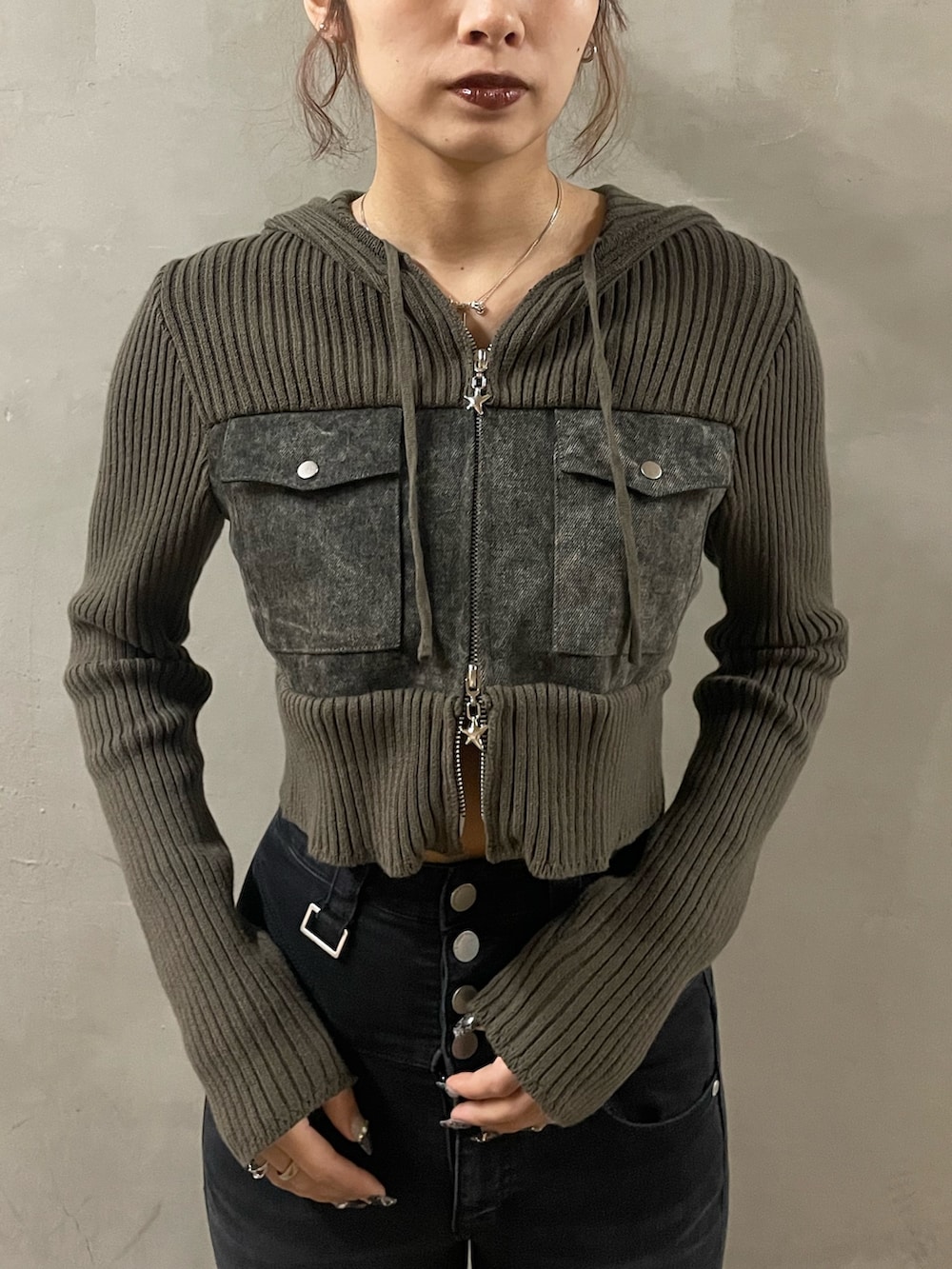 グリーン系のニット/セーター、ブラック系のデニムパンツ、ブラック系のサンダルを着用したレディースの春コーディネートの4枚目の写真