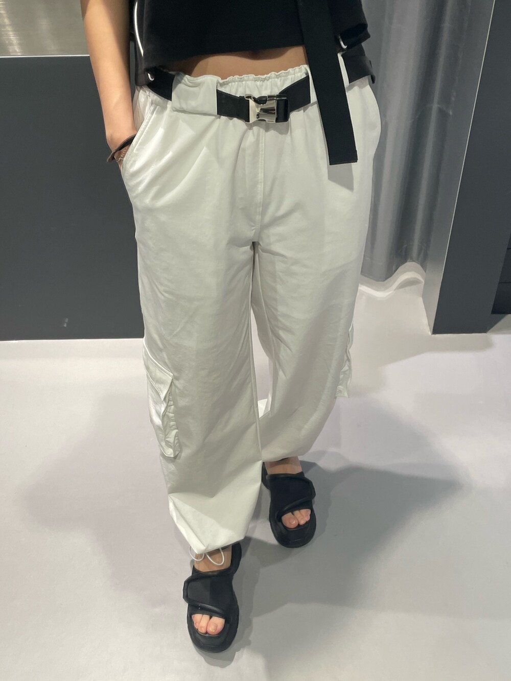 ブラック系のTシャツ/カットソー、ブラック系のハンドバッグ、ホワイト系のカーゴパンツを着用したレディースの春コーディネートの6枚目の写真