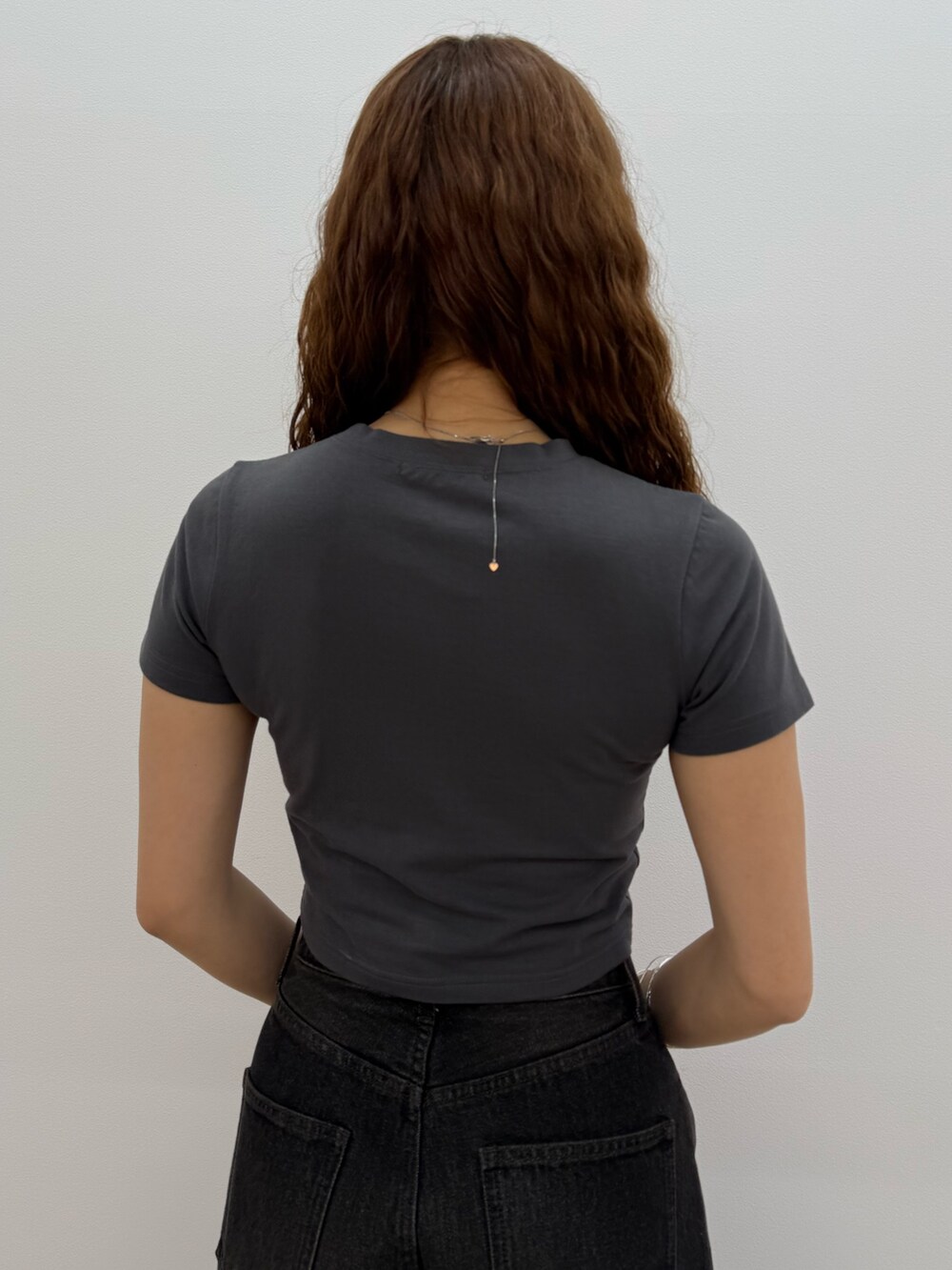 グレー系のTシャツ/カットソー、ブラック系のデニムパンツ、ブラック系のサンダルを着用したレディースの夏コーディネートの6枚目の写真