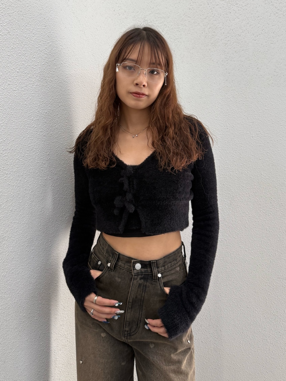 ブラック系のニット/セーター、ブラウン系のデニムパンツ、ブラック系のブーツを着用したレディースの秋コーディネートの4枚目の写真