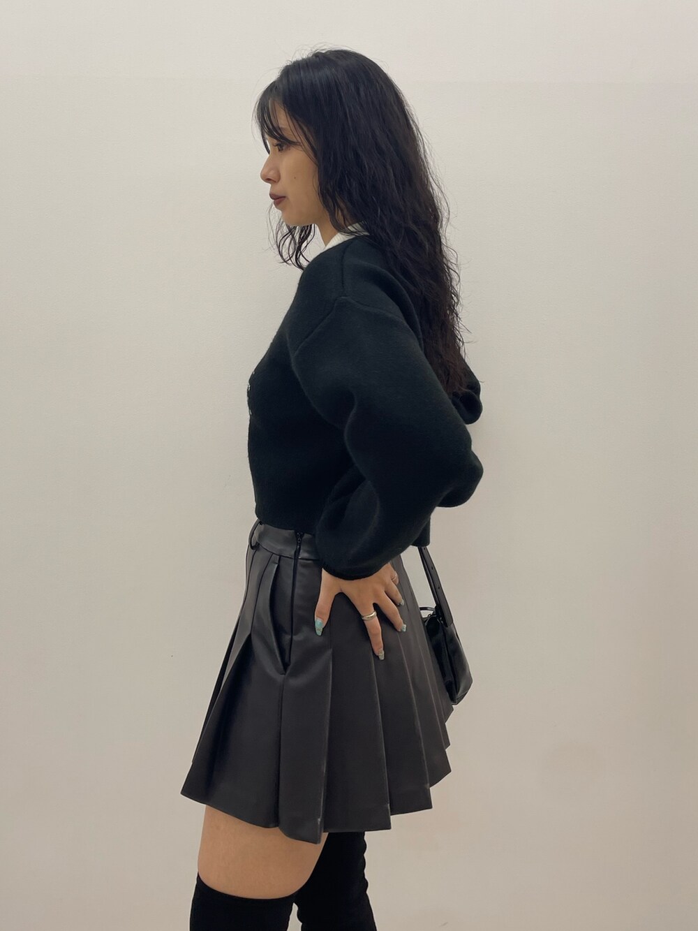 ブラック系のニット/セーター、グレー系のスカート、ブラック系のショルダーバッグを着用したレディースの夏コーディネートの5枚目の写真