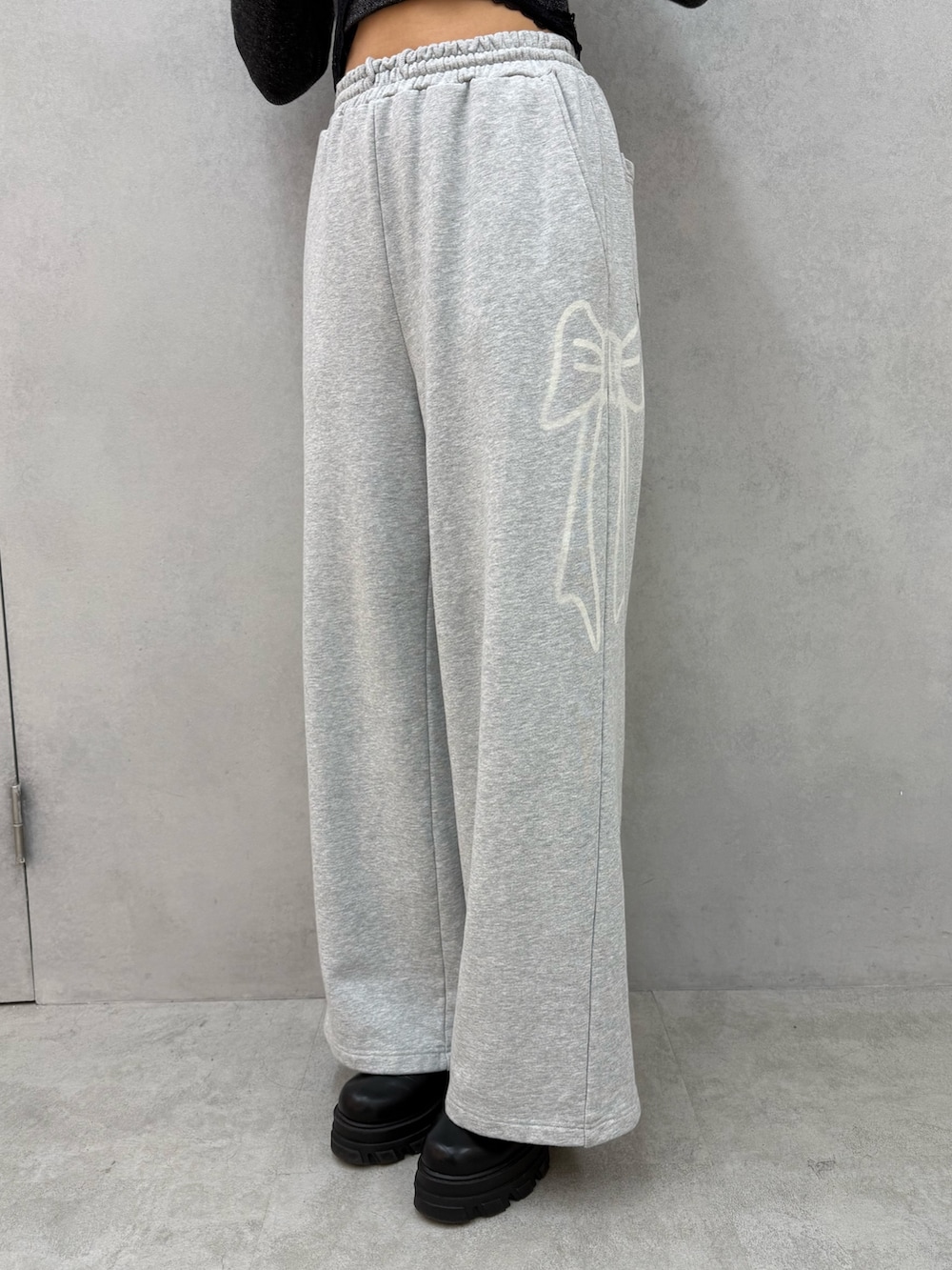 ブラック系のニット/セーター、グレー系のスウェットパンツ、ブラック系のブーツを着用したレディースの冬コーディネートの5枚目の写真