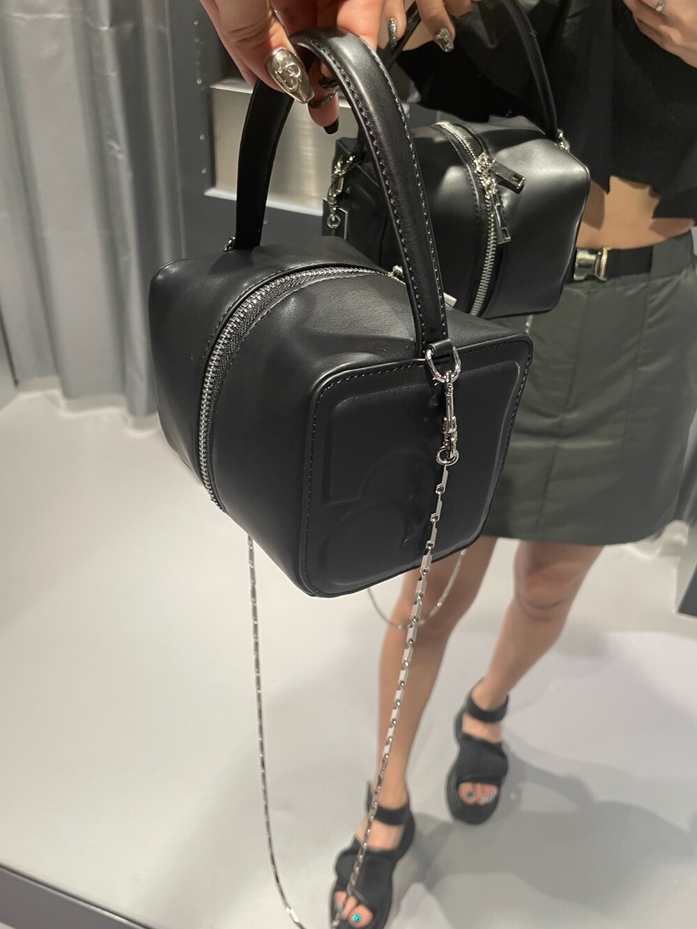 ブラック系のTシャツ/カットソー、ブラック系のハンドバッグ、グレー系のスカートを着用したレディースの夏コーディネートの9枚目の写真