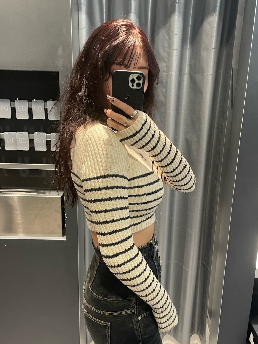 ホワイト系のニット/セーター、グレー系のブルゾン、ブルー系のデニムパンツを着用したレディースの秋コーディネートの7枚目の写真