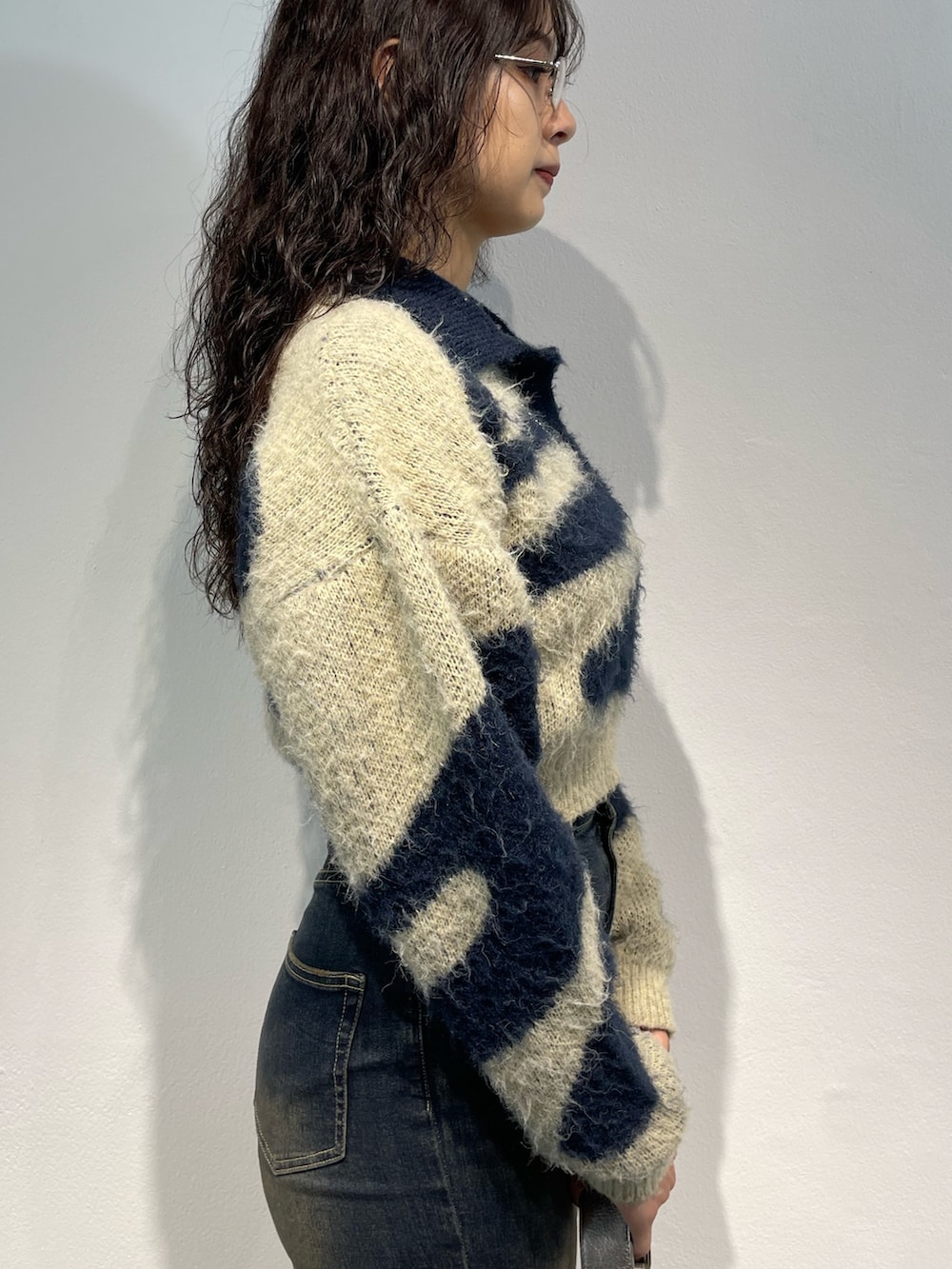 ブルー系のニット/セーター、ブラック系のスカート、ブラック系のハンドバッグを着用したレディースの秋コーディネートの5枚目の写真