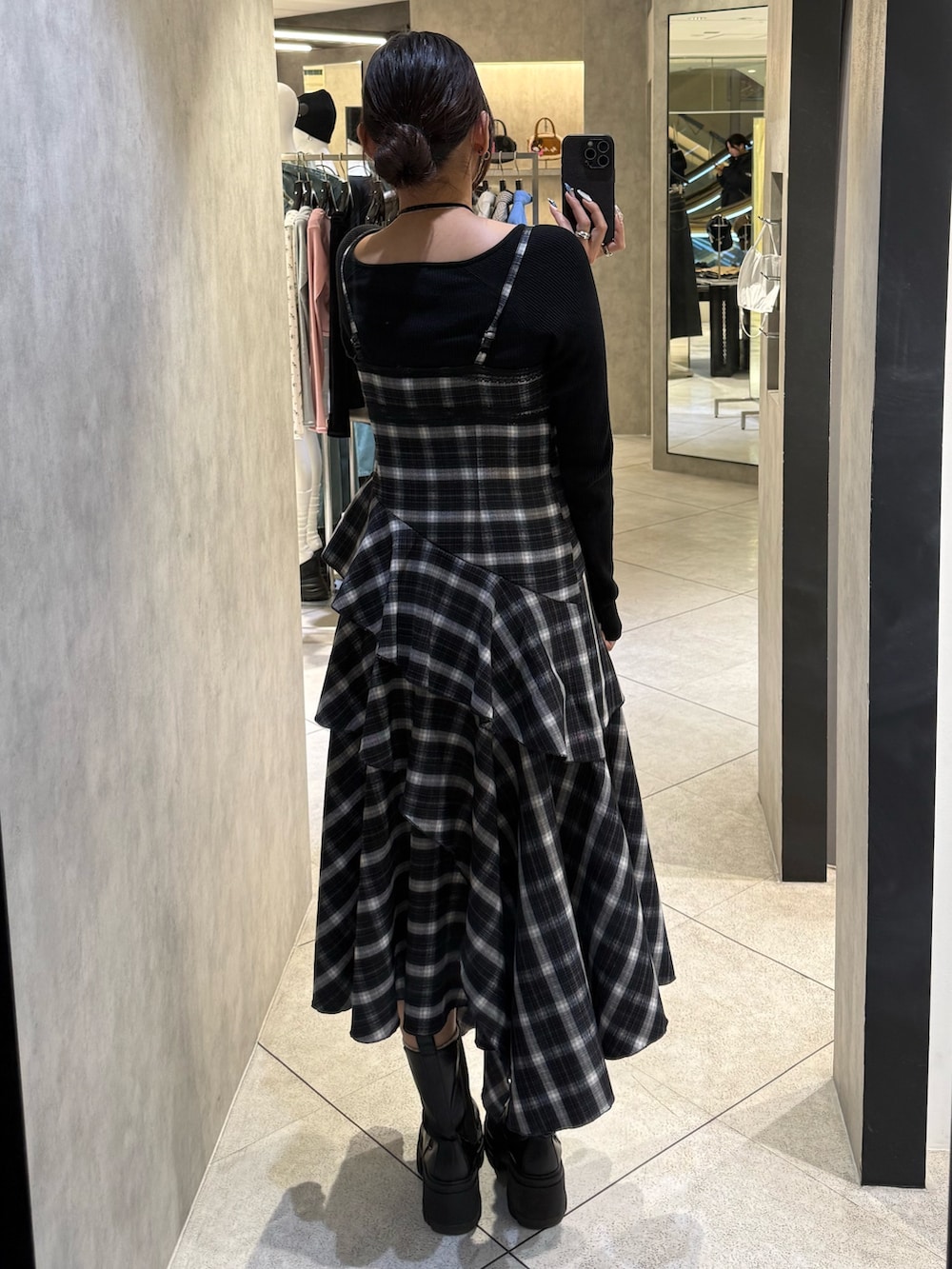 ブラック系のニット/セーター、ブラック系のワンピース、ブラック系のブーツを着用したレディースの春コーディネートの3枚目の写真