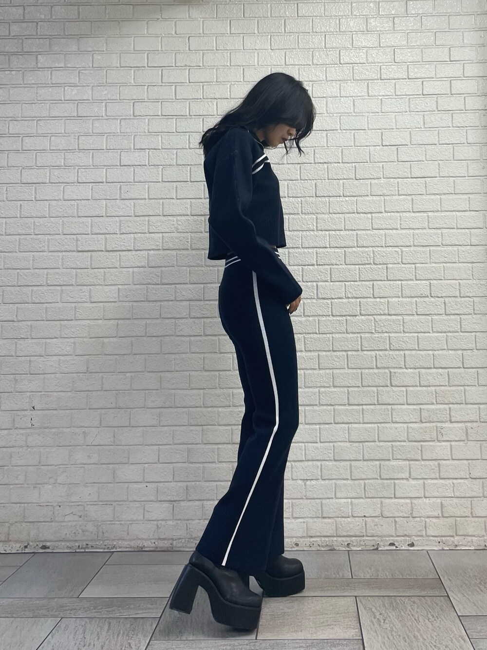 ブルー系のニット/セーター、ブルー系のその他パンツ、ブラック系のブーツを着用したレディースの秋コーディネートの2枚目の写真