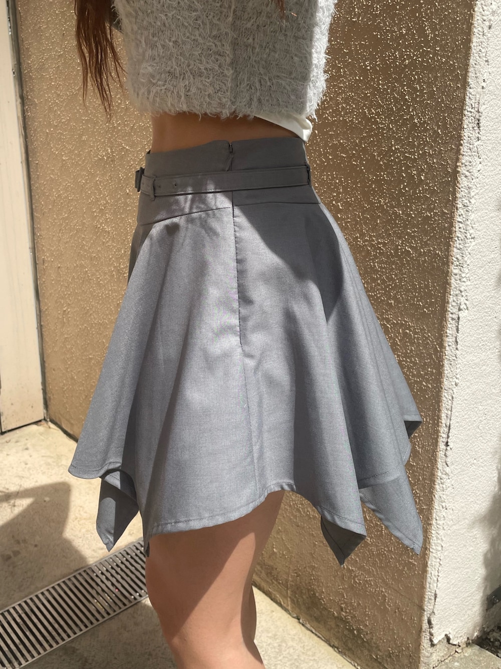 ブルー系のTシャツ/カットソー、グレー系のスカート、ブラック系のハンドバッグを着用したレディースの春コーディネートの7枚目の写真