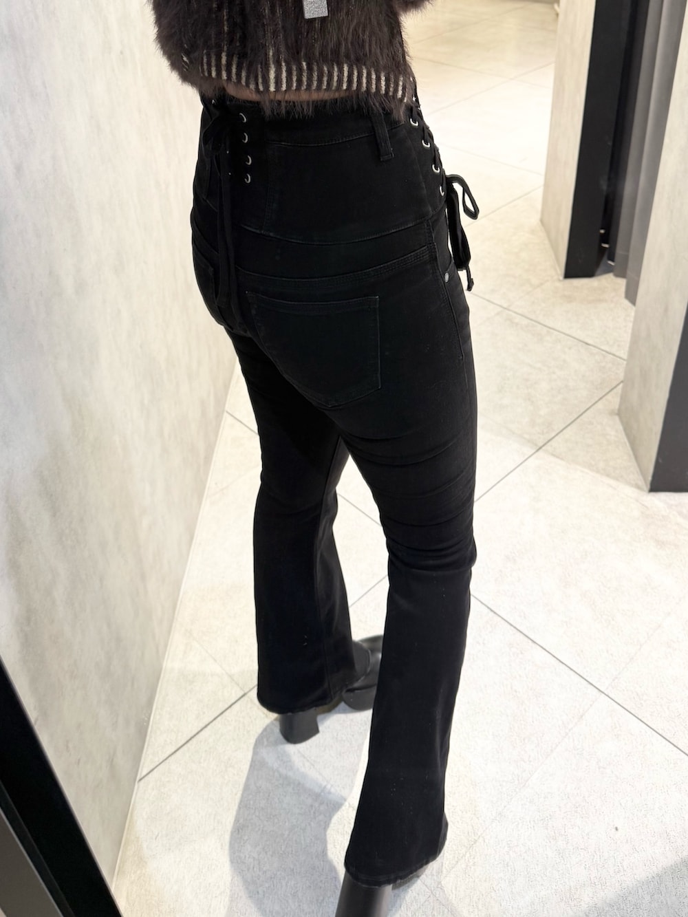 ブラウン系のニット/セーター、ブラック系のデニムパンツ、ブラック系のブーツを着用したレディースの秋コーディネートの7枚目の写真