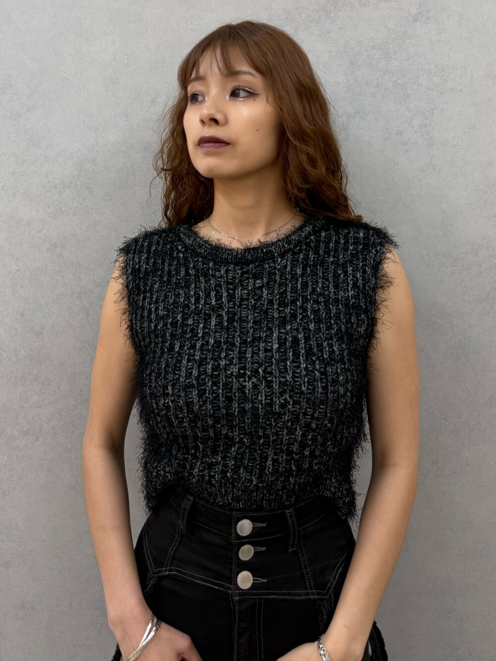 ブラック系のニット/セーター、ブラック系のデニムパンツ、ブラック系のハンドバッグを着用したレディースの夏コーディネートの4枚目の写真