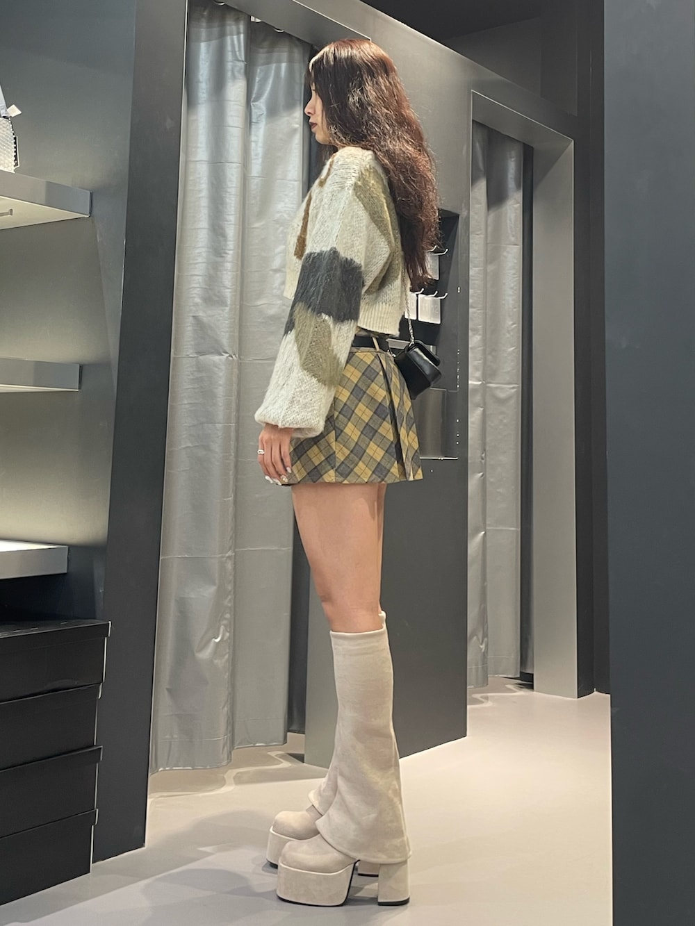ホワイト系のニット/セーター、その他のスカート、ホワイト系のブーツを着用したレディースの冬コーディネートの2枚目の写真