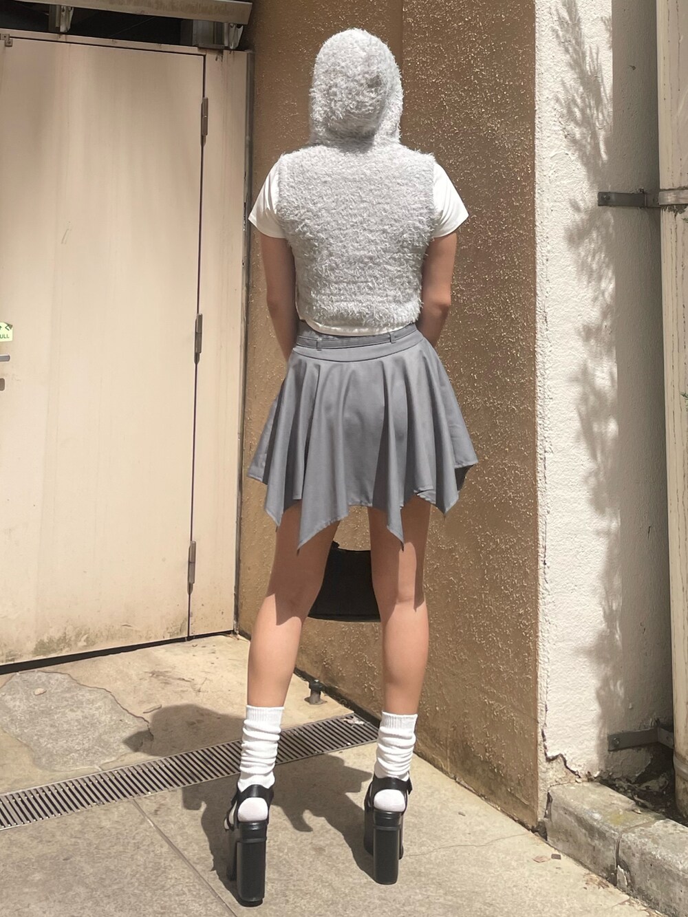 ホワイト系のTシャツ/カットソー、グレー系のニット/セーター、グレー系のスカートを着用したレディースの春コーディネートの3枚目の写真