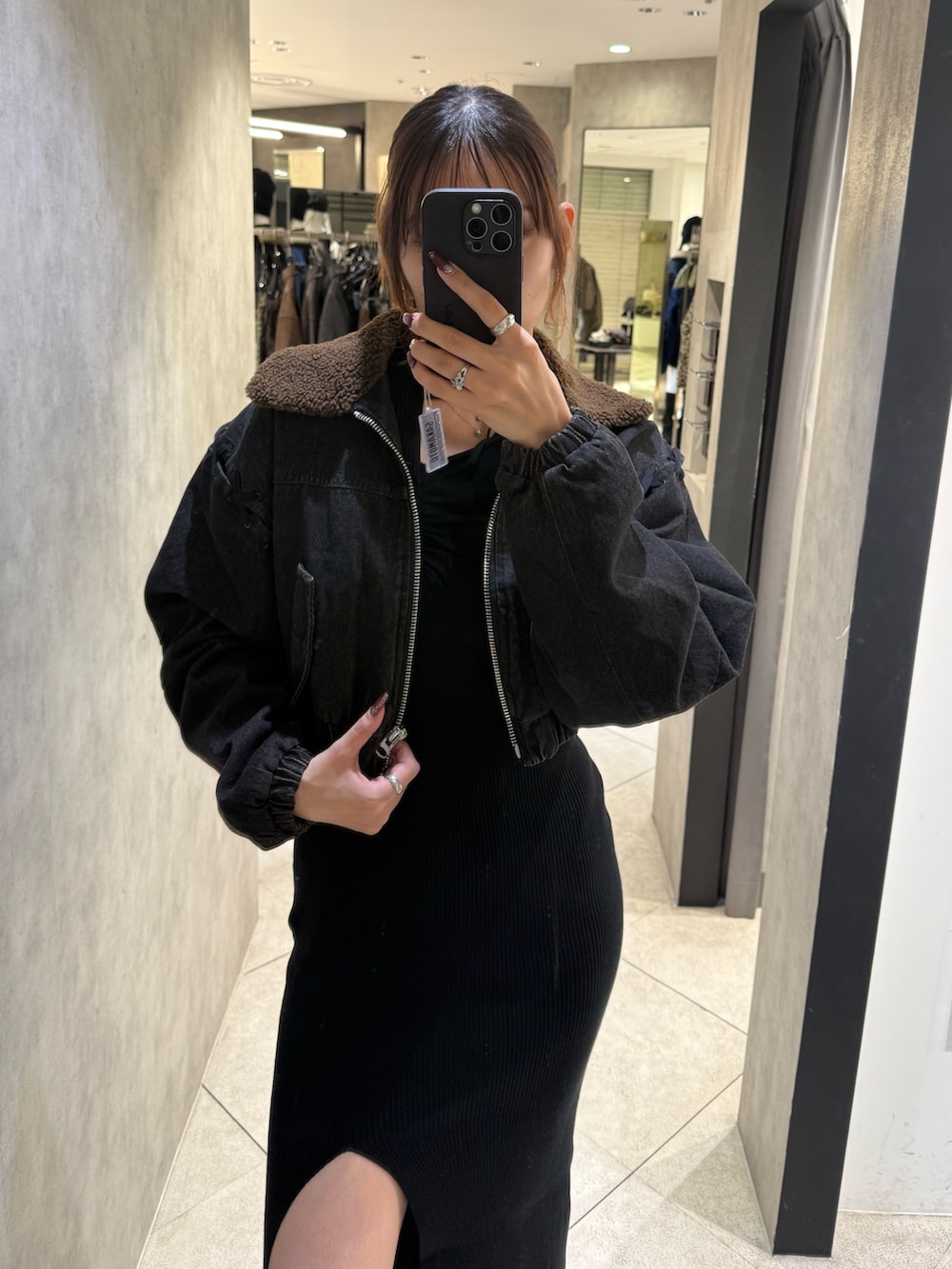 ブラック系のブルゾン、ブラック系のワンピース、ブラック系のブーツを着用したレディースの秋コーディネートの4枚目の写真