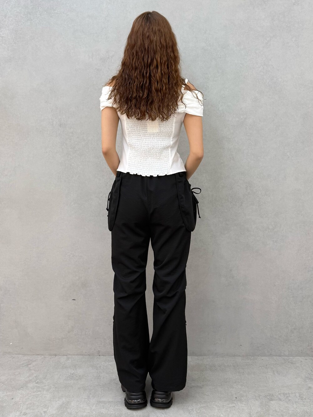 ホワイト系のTシャツ/カットソー、ブラック系のその他パンツ、ブラック系のサンダルを着用したレディースの夏コーディネートの3枚目の写真