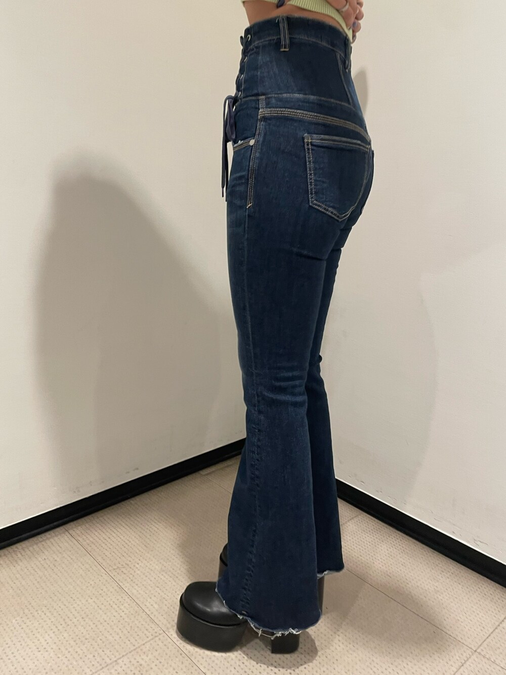 グリーン系のニット/セーター、ブルー系のデニムパンツ、ブラック系のブーツを着用したレディースの冬コーディネートの8枚目の写真