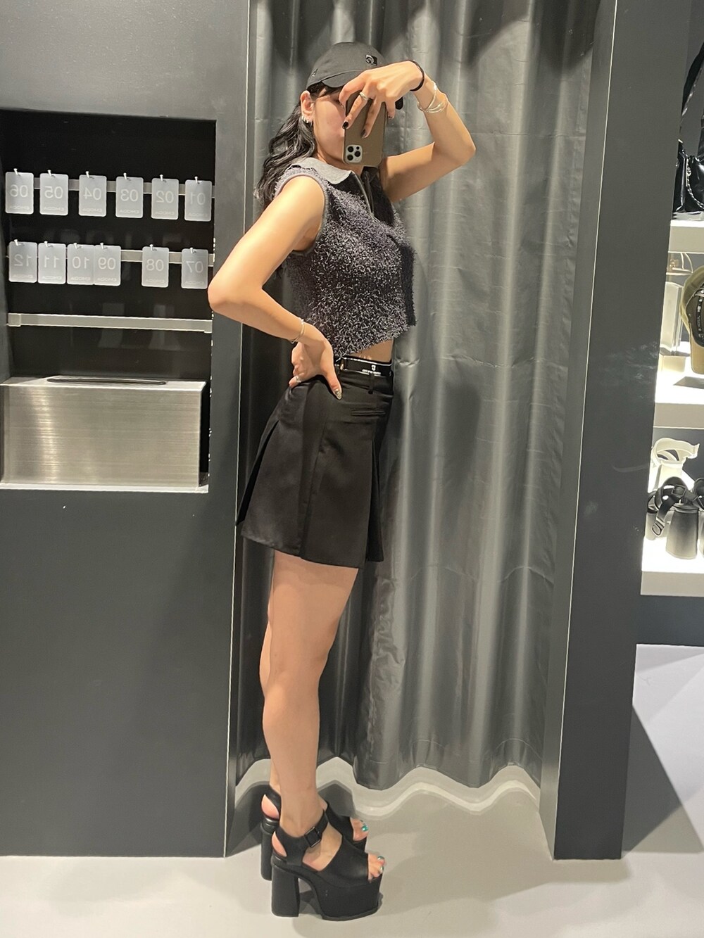 グレー系のタンクトップ、ブラック系のスカート、ブラック系のサンダルを着用したレディースの夏コーディネートの2枚目の写真