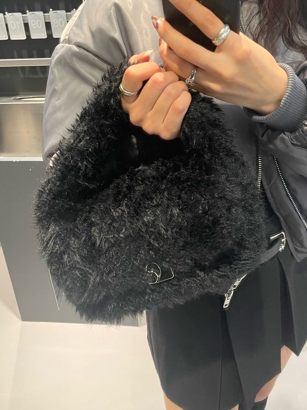 ブラック系のTシャツ/カットソー、グレー系のブルゾン、ブラック系のスカートを着用したレディースの冬コーディネートの8枚目の写真