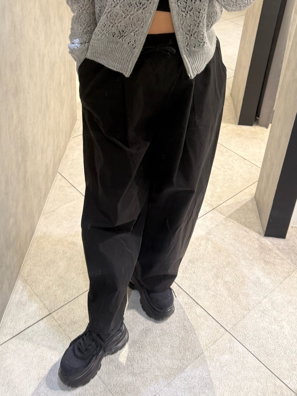 グレー系のTシャツ/カットソー、ブラック系のその他パンツ、ブラック系のスニーカーを着用したレディースの春コーディネートの5枚目の写真