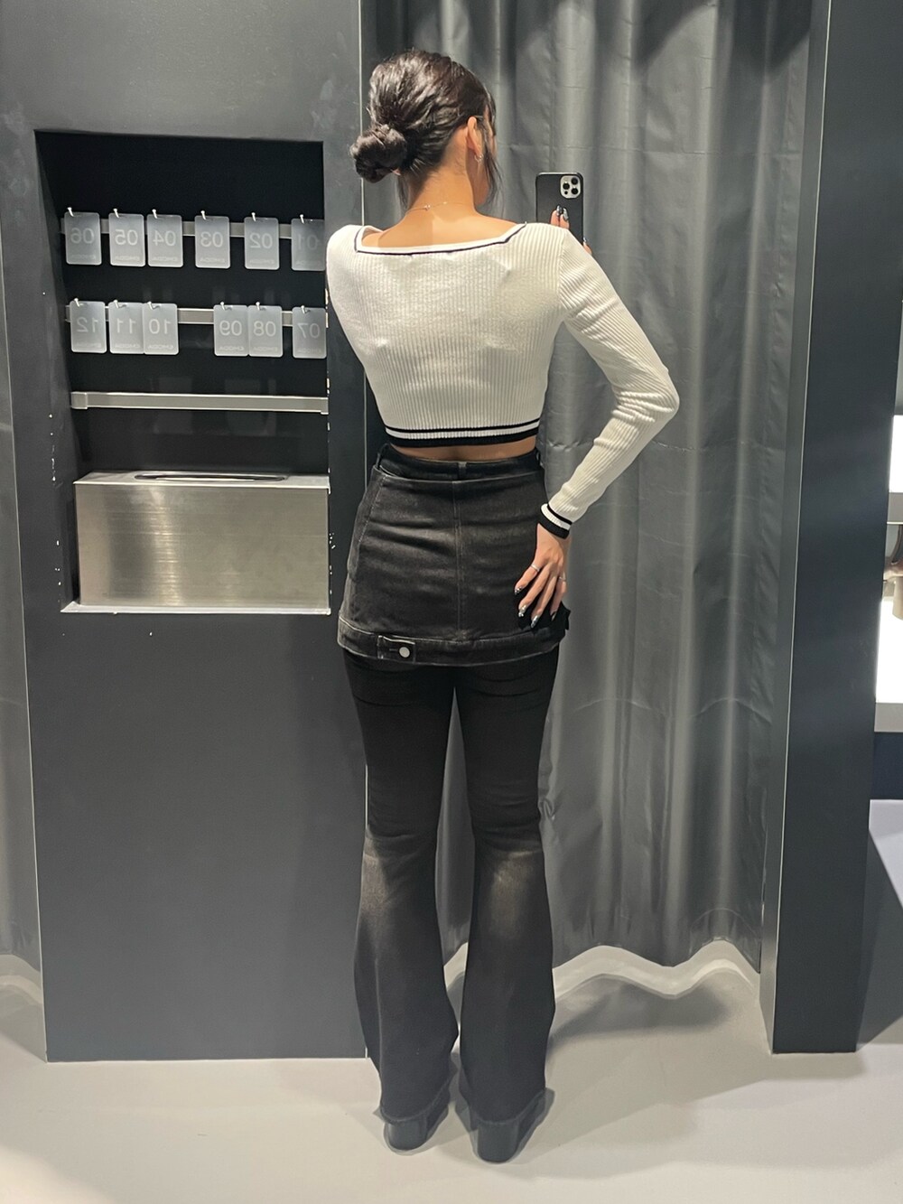 ホワイト系のニット/セーター、ブラック系のデニムパンツ、ブラック系のブーツを着用したレディースの秋コーディネートの3枚目の写真