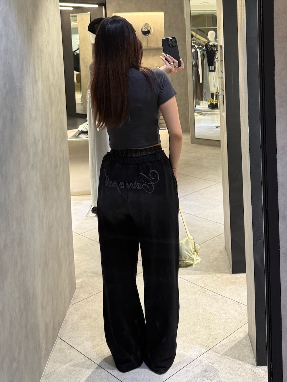 グレー系のTシャツ/カットソー、ブラック系のスウェットパンツ、イエロー系のハンドバッグを着用したレディースの春コーディネートの3枚目の写真