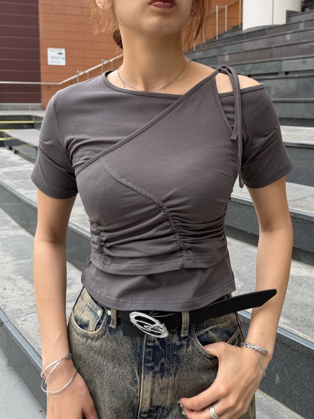 グレー系のTシャツ/カットソー、ブルー系のデニムパンツ、ブラック系のショルダーバッグを着用したレディースの春コーディネートの4枚目の写真