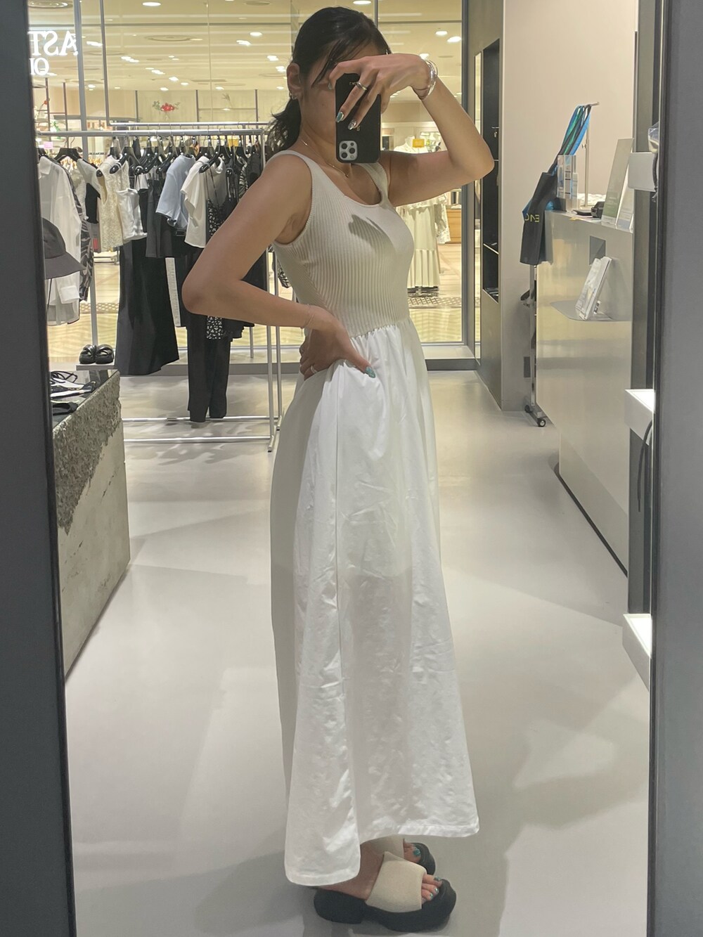 ホワイト系のワンピース、ホワイト系のサンダル、シルバー系のネックレスを着用したレディースの夏コーディネートの2枚目の写真