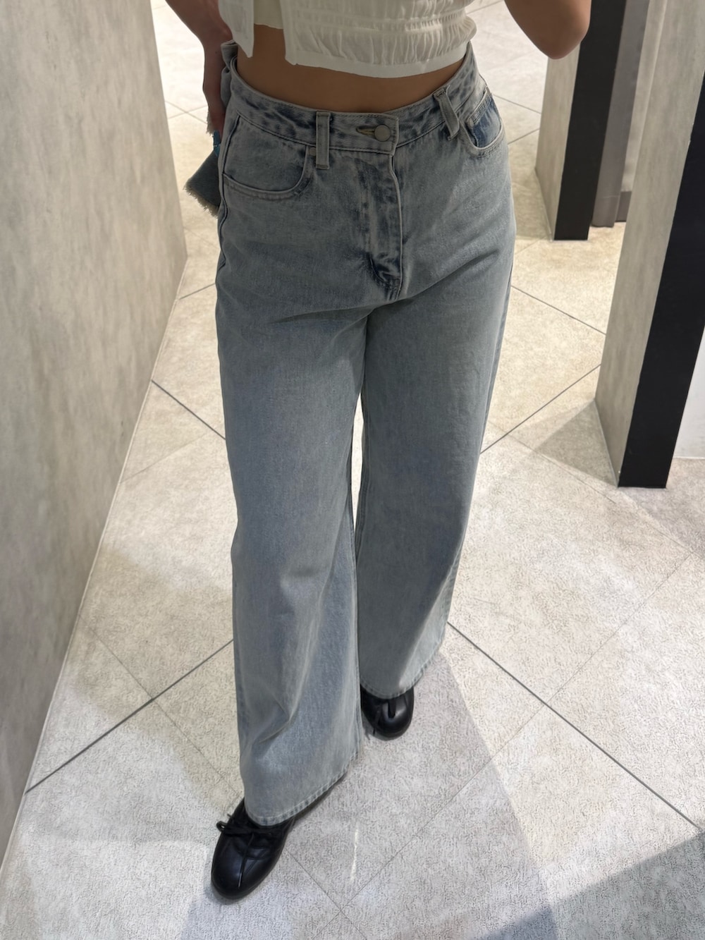 ホワイト系のニット/セーター、ブルー系のデニムパンツ、ブラック系のスニーカーを着用したレディースの春コーディネートの5枚目の写真