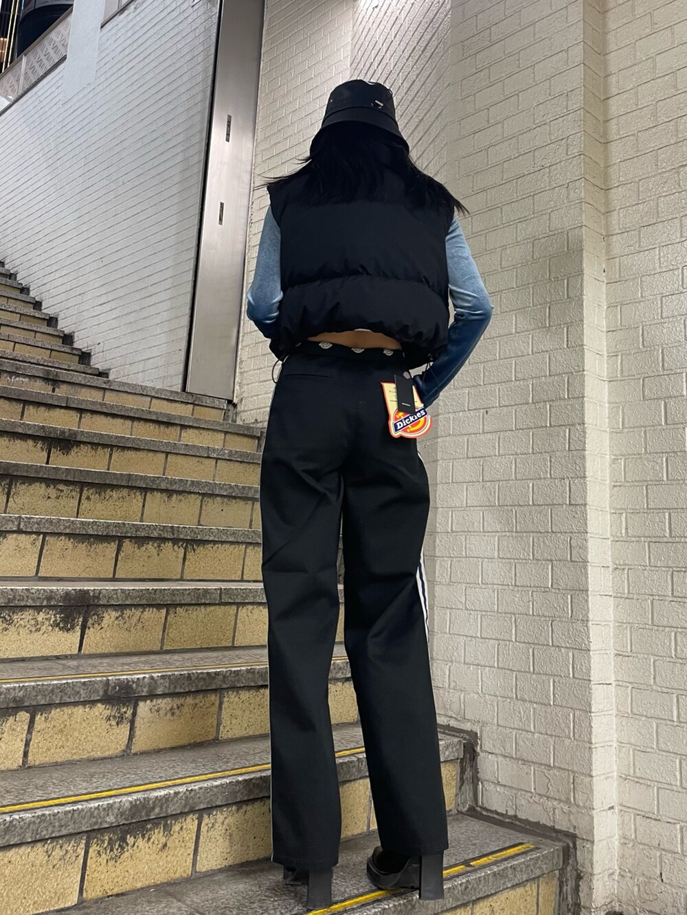 ブラック系のダウンベスト、ブルー系のTシャツ/カットソー、ブラック系のその他パンツを着用したレディースの秋コーディネートの3枚目の写真