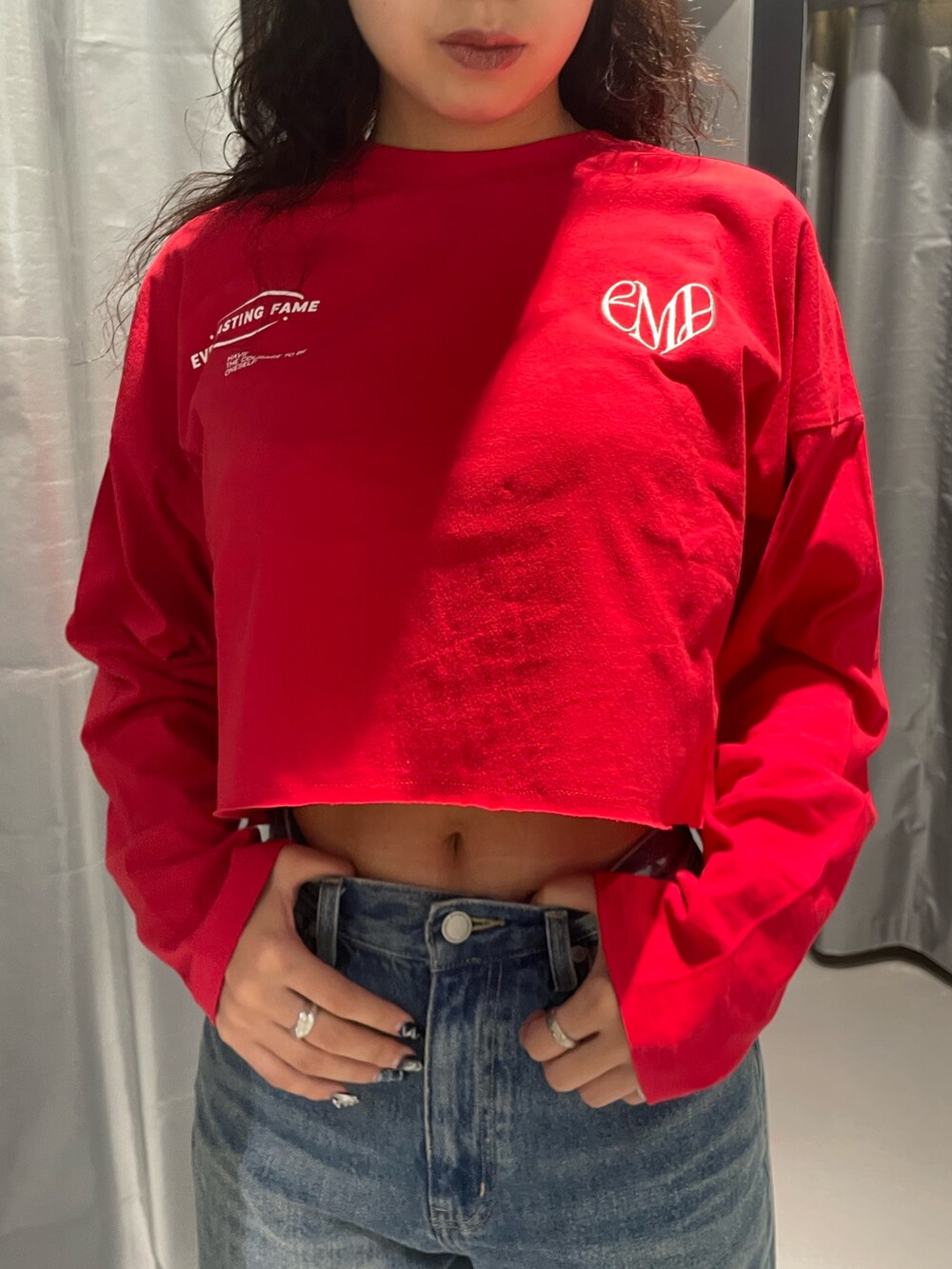 レッド系のTシャツ/カットソー、ブルー系のデニムスカート、その他のブーツを着用したレディースの秋コーディネートの4枚目の写真