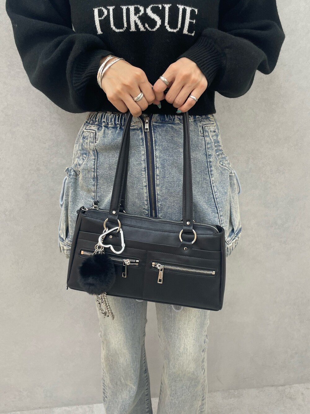 ブラック系のニット/セーター、ブルー系のデニムパンツ、ブラック系のショルダーバッグを着用したレディースの夏コーディネートの10枚目の写真