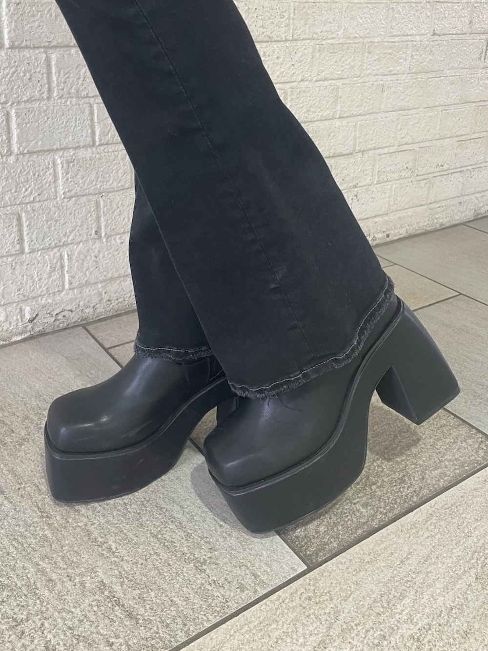 グレー系のニット/セーター、ブラック系のデニムパンツ、ブラック系のブーツを着用したレディースの冬コーディネートの10枚目の写真