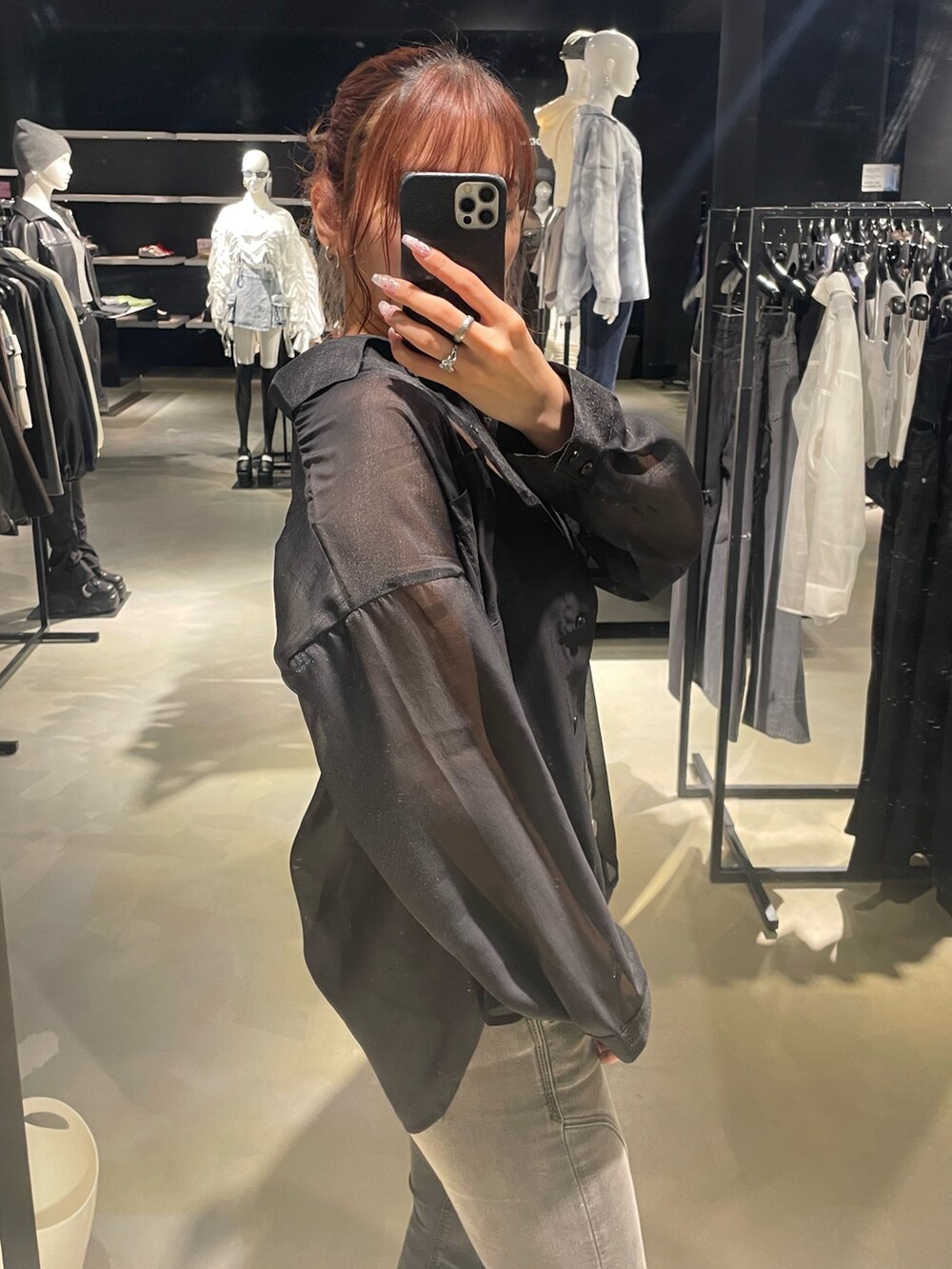 ブラック系のニット/セーター、ブラック系のシャツ/ブラウス、ブラック系のデニムパンツを着用したレディースの春コーディネートの5枚目の写真