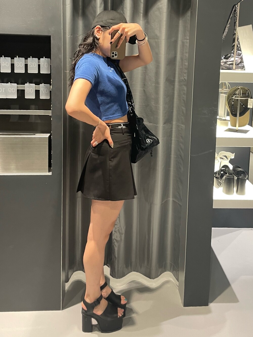 ブルー系のTシャツ/カットソー、ブラック系のハンドバッグ、ブラック系のスカートを着用したレディースの夏コーディネートの2枚目の写真