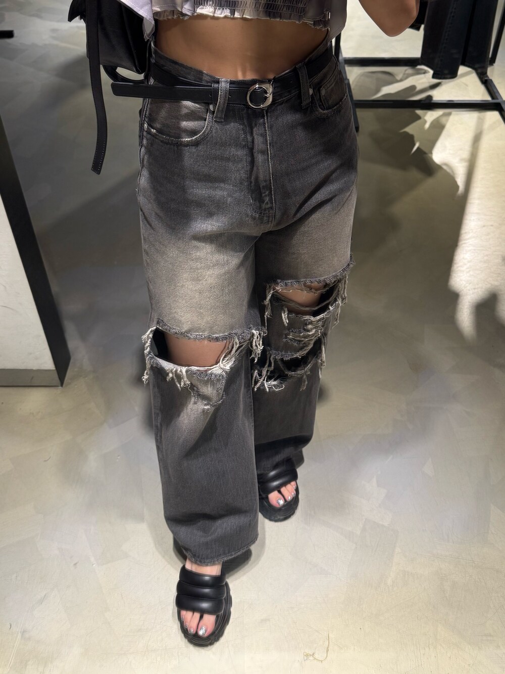 ベージュ系のTシャツ/カットソー、ブラック系のハンドバッグ、ブラック系のデニムパンツを着用したレディースの夏コーディネートの6枚目の写真