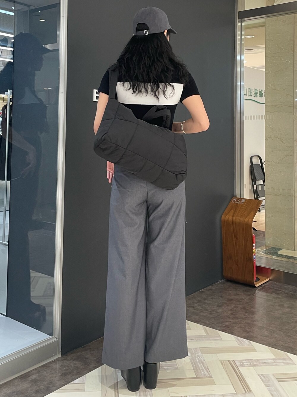 ブラック系のTシャツ/カットソー、グレー系のその他パンツ、ブラック系のサンダルを着用したレディースの春コーディネートの3枚目の写真