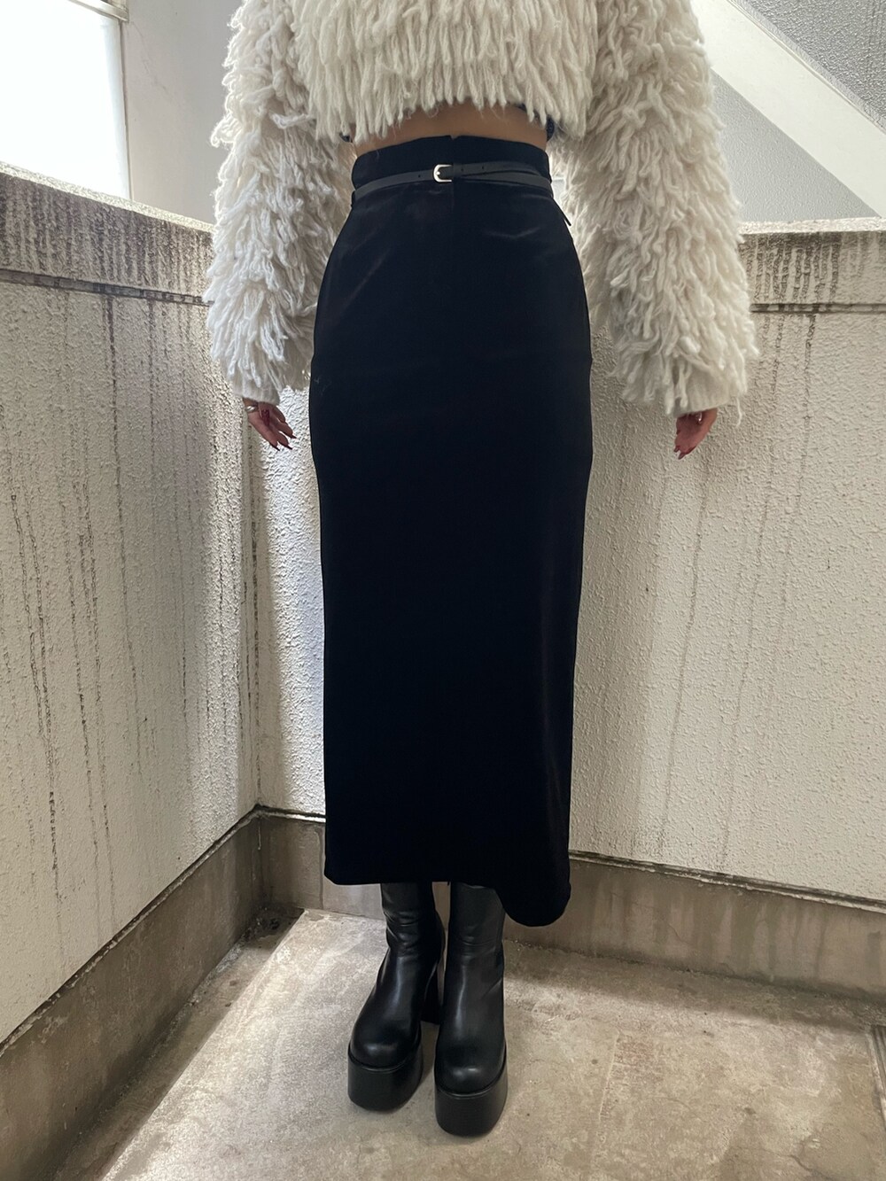 グレー系のニット/セーター、ブラック系のハンドバッグ、ブラック系のスカートを着用したレディースの秋コーディネートの7枚目の写真