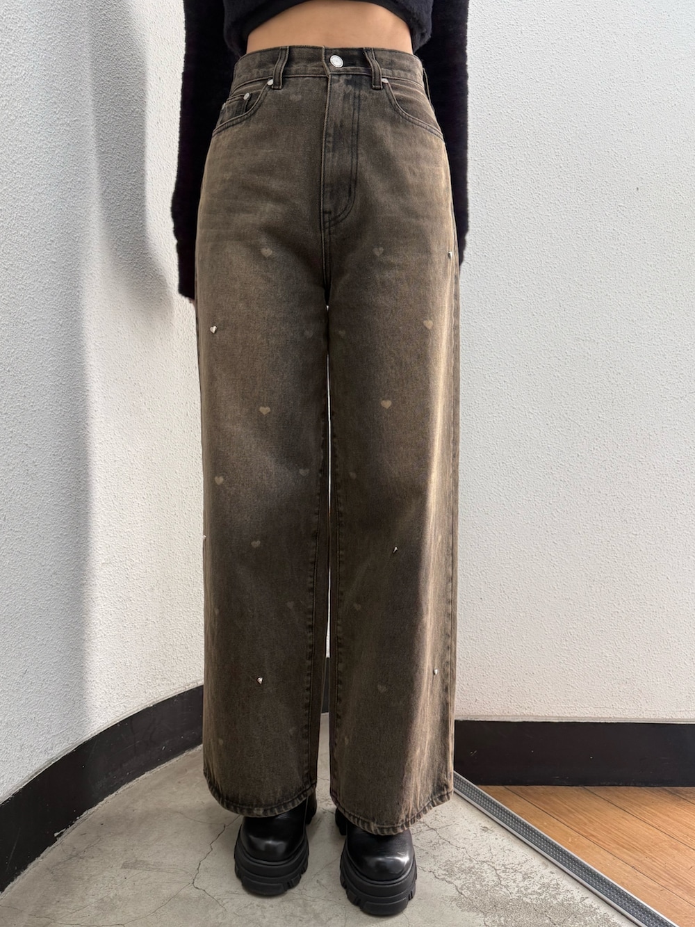 ブラック系のニット/セーター、ブラウン系のデニムパンツ、ブラック系のブーツを着用したレディースの秋コーディネートの5枚目の写真