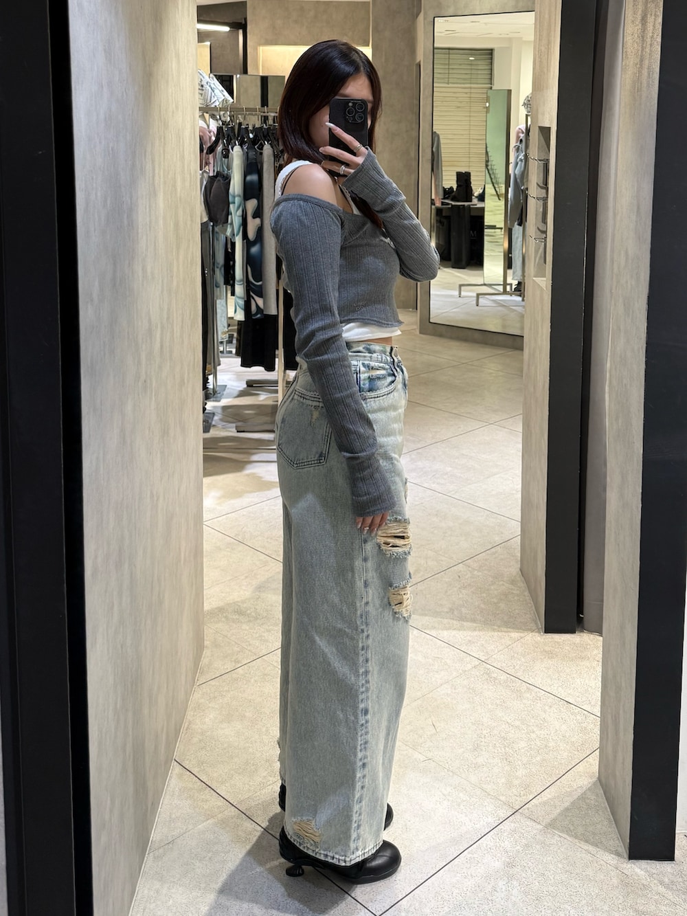 グレー系のTシャツ/カットソー、ブルー系のデニムパンツ、ブラック系のスニーカーを着用したレディースの春コーディネートの2枚目の写真