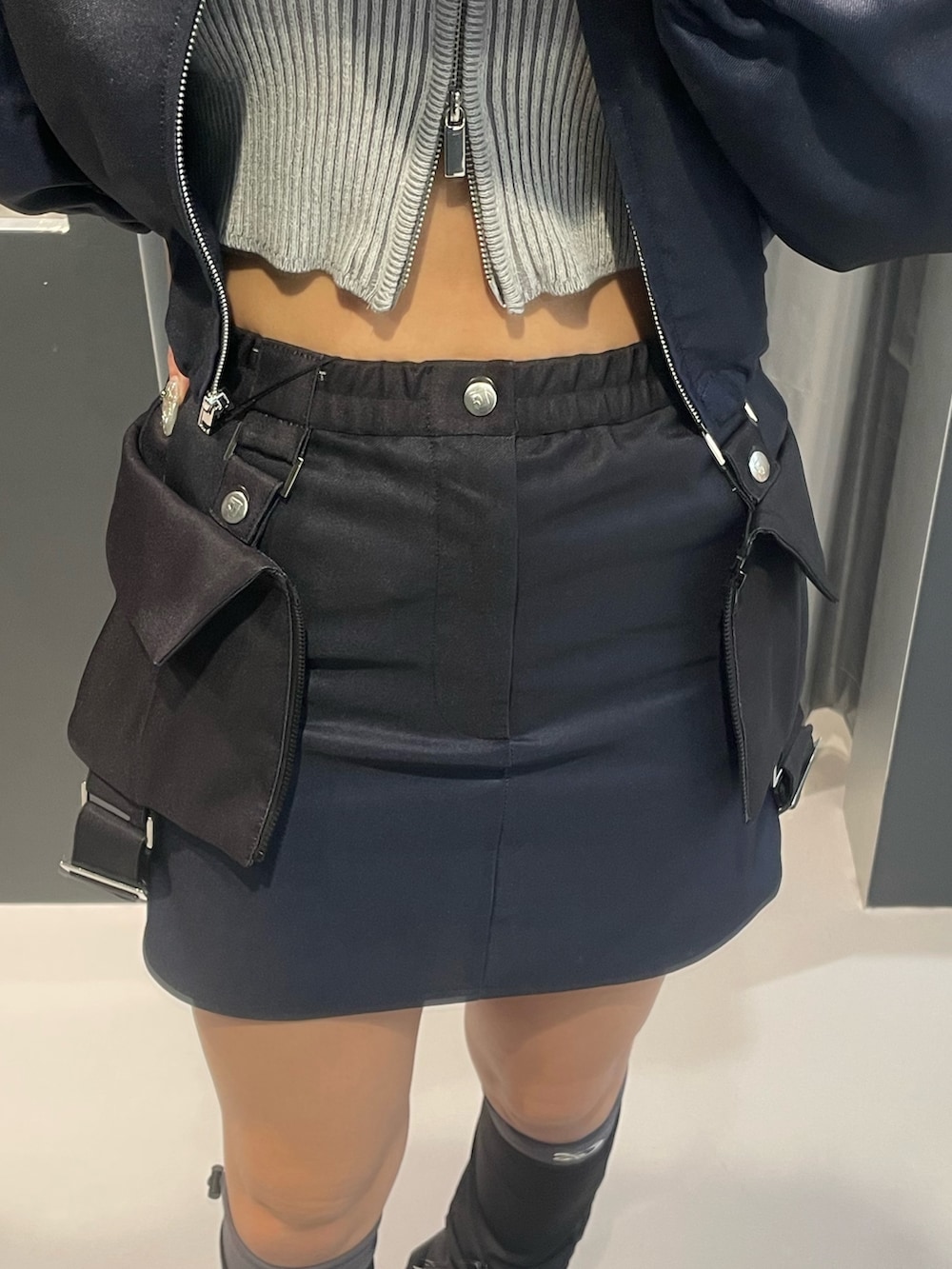 ブルー系のブルゾン、グレー系のニット/セーター、ブルー系のスカートを着用したレディースの冬コーディネートの6枚目の写真